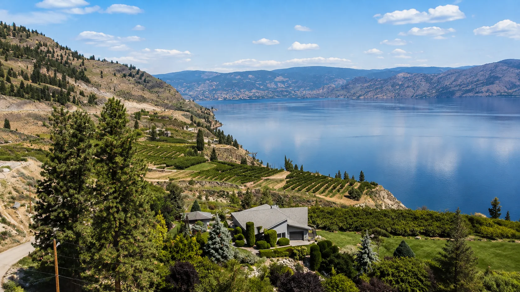 Terraced vineyards and a hillside home above Okanagan Lake in Lake Country, British Columbia